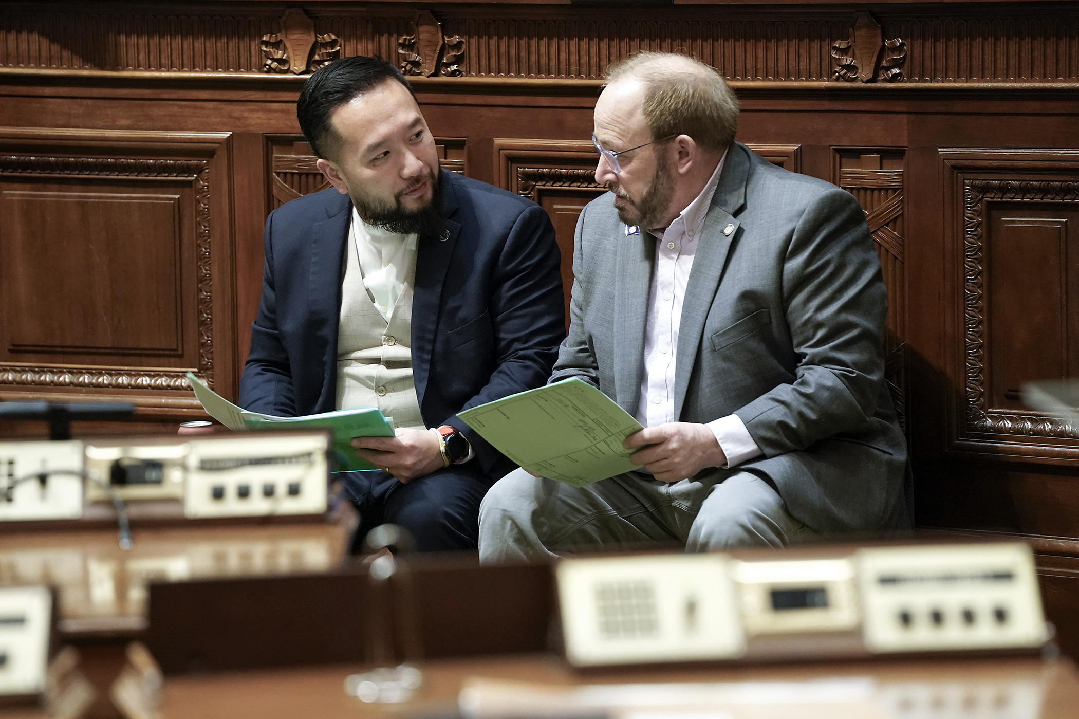 Rep. Fue Lee and Rep. Roger Skraba discuss legislation following a March 20 floor session. (Photo by Michele Jokinen)